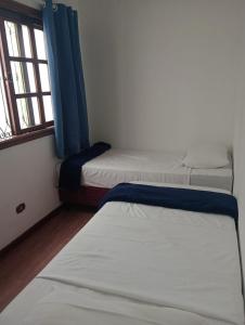 a room with three beds and a window at Hostel BoituVillage in Boituva