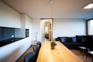 uma sala de estar com uma mesa de madeira e um sofá em Berg Aparts - Top 6 - Faschina - mit Sauna & 2 Bädern em Fontanella