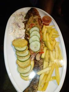 un plato de comida con patatas fritas y verduras en JOEL'S HOTELS & SUITES, en Ikeja
