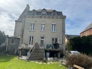 een groot bakstenen gebouw met een trap ervoor bij Le Petit Chateau in Saint-Michel