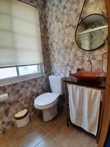 een badkamer met een toilet en een spiegel bij Casa Topázio no Container dos Cristais in Delfinópolis