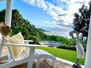 a white rocking chair and a pelican on a patio at COCOVIEW BEACH HOUSE in Southbroom