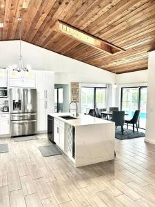 une grande cuisine avec des placards blancs et une table dans l'établissement Luxurious pool home in Palm Beach County, Florida, à Wellington