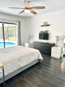 - une chambre avec un lit et un ventilateur de plafond dans l'établissement Luxurious pool home in Palm Beach County, Florida, à Wellington