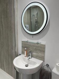 bagno con lavandino e specchio a parete di Watts Lodge a Bicester