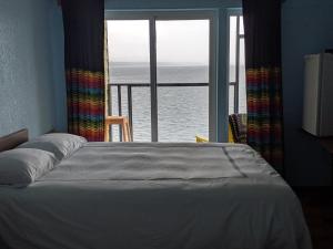 Schlafzimmer mit einem Bett und Meerblick in der Unterkunft The Oceanfront Hotel in Sointula