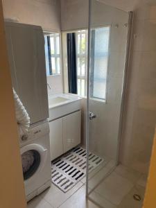 a bathroom with a washing machine and a sink at Estrela Mares Haifa apartment in Haifa +15 photos