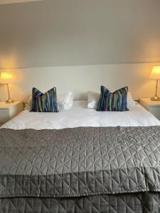 a bedroom with a large bed with two lamps at Watts Lodge in Bicester