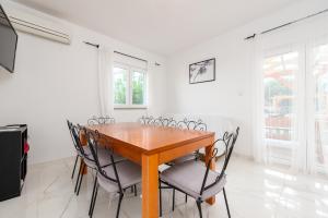 a dining room with a wooden table and chairs at Home with a unique view in Preko