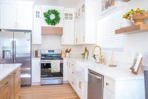 a kitchen with white cabinets and a stainless steel refrigerator at Rustic Gold Retreat in Kanab