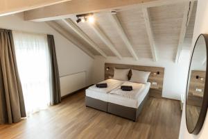 - une chambre avec un grand lit et une grande fenêtre dans l'établissement Kapfwald Appartements, à Bad Dürrheim