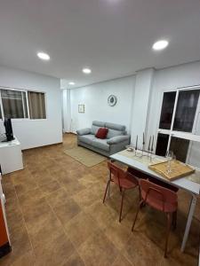 Apartamento puestas de sol في شيكلانا دي لا فرونتيرا: غرفة معيشة مع أريكة وطاولة وكراسي