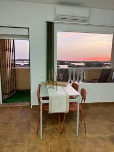 Apartamento puestas de sol في شيكلانا دي لا فرونتيرا: غرفة طعام مع طاولة بيضاء وكراسي
