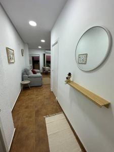 einen Flur mit einem Spiegel an der Wand und einer Couch in der Unterkunft Apartamento puestas de sol in Chiclana de la Frontera