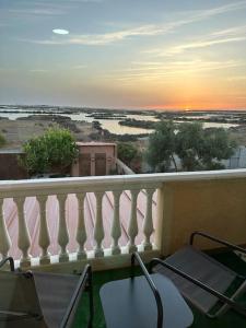Un balcón con sillas y vistas al océano. en Apartamento puestas de sol, en Chiclana de la Frontera
