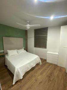 1 dormitorio con cama blanca y techo en Apartamento Turístico Campo de la Verdad en Córdoba
