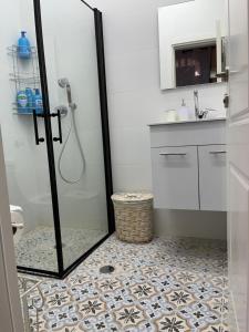 a bathroom with a shower with a tile floor at La Provençale in Jerusalem