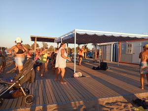 a group of people on a beach with a pier at Chez Berna - Se Alquila Habitacion in Denia