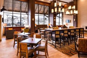 a restaurant with tables and chairs and a bar at Hampton Inn & Suites Silverthorne in Silverthorne