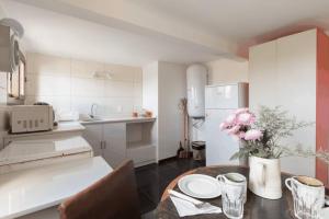 a kitchen with a table with a vase of flowers at Penthouse with terrace at the Old City in Montevideo