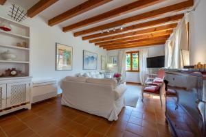 a living room with a white couch and a tv at Sa Finqueta, Luxury Elegant Mansion with breathtaking views of Soller in Sóller