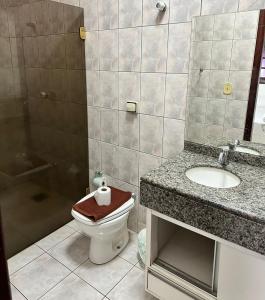 a bathroom with a toilet and a sink and a shower at HOTEL MARAMBAIA in Ponta Porã
