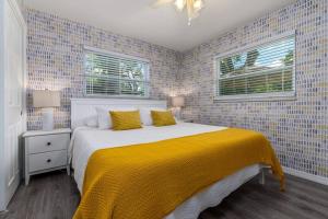 ein Schlafzimmer mit einem großen Bett und einer gelben Decke in der Unterkunft NEW - Sweet Saint Pete in St Petersburg