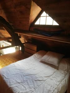 um quarto com uma cama branca e uma janela em Grande maison au calme au cœur d un bois em Ferrières