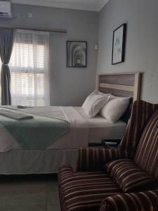 a bedroom with a large bed and a couch at Serene Cottage in Francistown