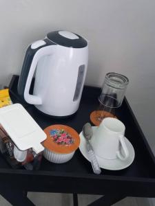 a black table with a toaster and a cupcake at Serene Cottage in Francistown