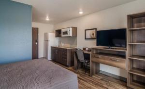 a hotel room with a bed and a desk with a television at WoodSpring Suites Ashland - Richmond North in Ashland