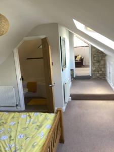 a bedroom with a bed and a stairway with a stair at Mendip Edge Retreat in Farrington Gurney