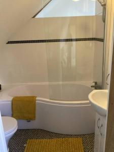 a bathroom with a tub and a toilet and a sink at Mendip Edge Retreat in Farrington Gurney