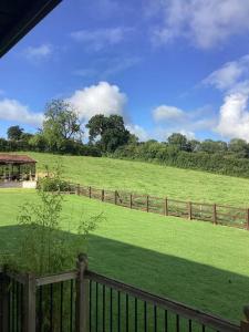 a field with a fence and a gazebo at Mendip Edge Retreat in Farrington Gurney