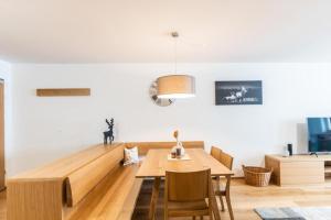 a dining room with a wooden table and chairs at Faschina Apartment - Top 4 in Fontanella