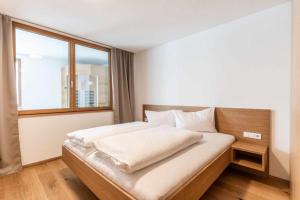 a bedroom with a bed with a large window at Faschina Apartment - Top 4 in Fontanella