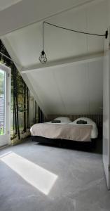 een slaapkamer met een bed in een witte kamer bij Evergreen wellness met sauna & hottub in Ewijk