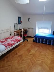 sypialnia z 2 łóżkami i biurkiem w obiekcie Spacious Attic Apartment Kandler w Trieście