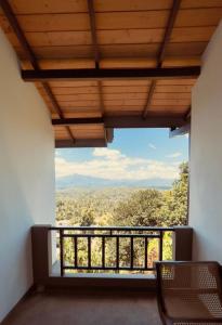 a room with a balcony with a view at The Hills By Blue Fox in Kandy