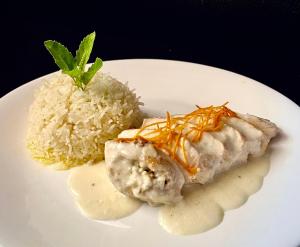 a white plate of food with rice and meat at Hotel Royal Bengal in Bolpur