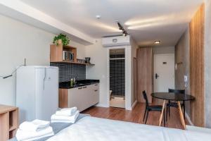 eine Küche mit einem Kühlschrank und einem Tisch im Zimmer in der Unterkunft 360 Praça da Árvore in São Paulo