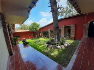 - une vue sur l'extérieur d'une maison avec un arbre dans la cour dans l'établissement Posada Los Colorines, à Zinapécuaro de Figueroa