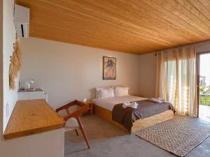 sypialnia z łóżkiem i drewnianym sufitem w obiekcie Casa Caju Tatajuba w mieście Tatajuba