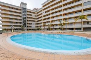 una gran piscina frente a un gran edificio de apartamentos en By the Sea II - calmo com piscina e vista mar., en Funchal