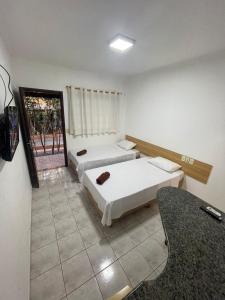 a hotel room with two beds and a mirror at HOTEL MARAMBAIA in Ponta Porã