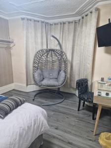 a bedroom with a wicker chair and a table at Highfields House in Sheffield
