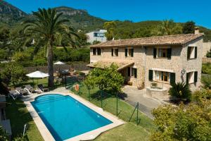 a villa with a swimming pool in front of a house at Sa Finqueta, Luxury Elegant Mansion with breathtaking views of Soller in Sóller