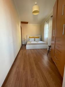 a bedroom with a bed and a wooden floor at Cosy 2 bedroom home in the heart of Jardim do Mar in Jardim do Mar