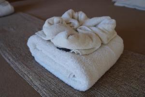 una pila de toallas blancas sentadas en una cama en Las Restingas Hotel De Mar en Puerto Pirámides