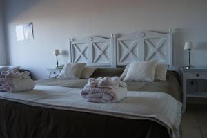 a bedroom with a large bed with towels on it at Las Restingas Hotel De Mar in Puerto Pirámides